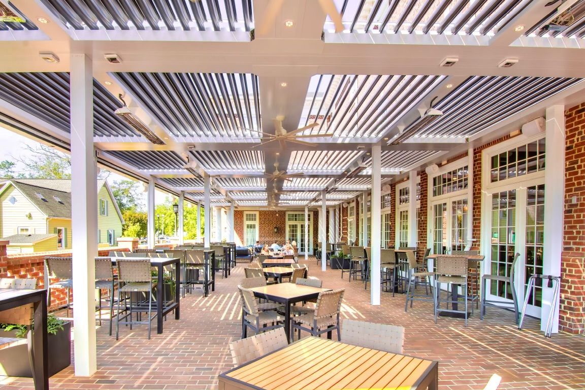 A large patio with tables and chairs under a canopy.