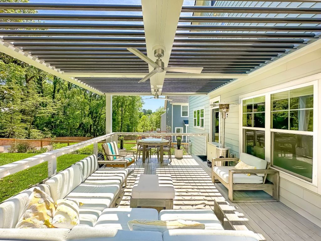 A large patio with a pergola and a ceiling fan.