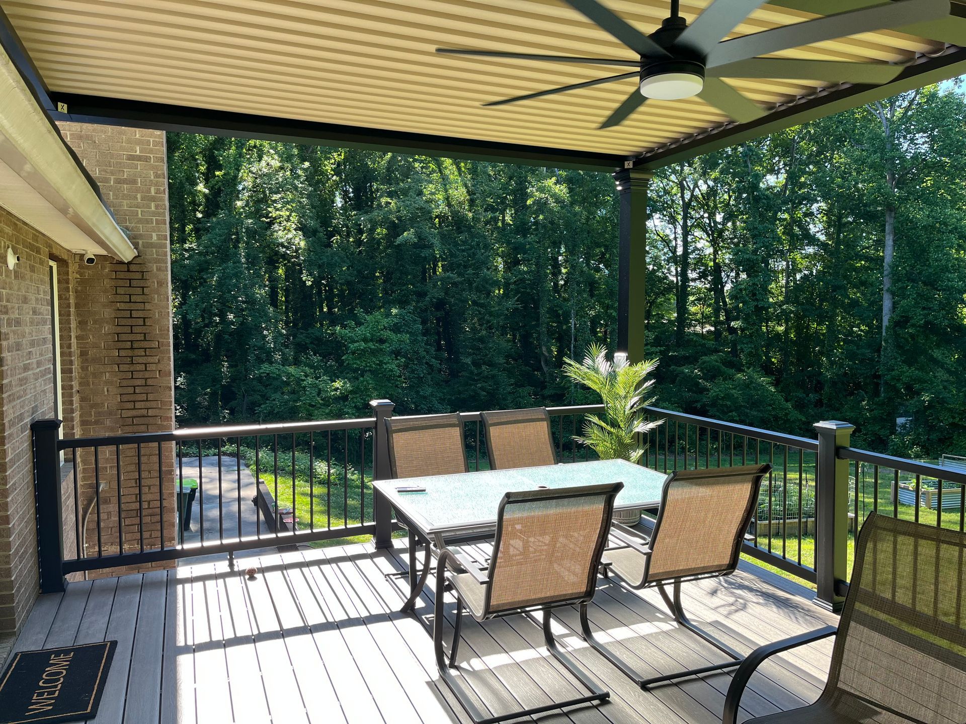 A deck with a table and chairs and a ceiling fan.
