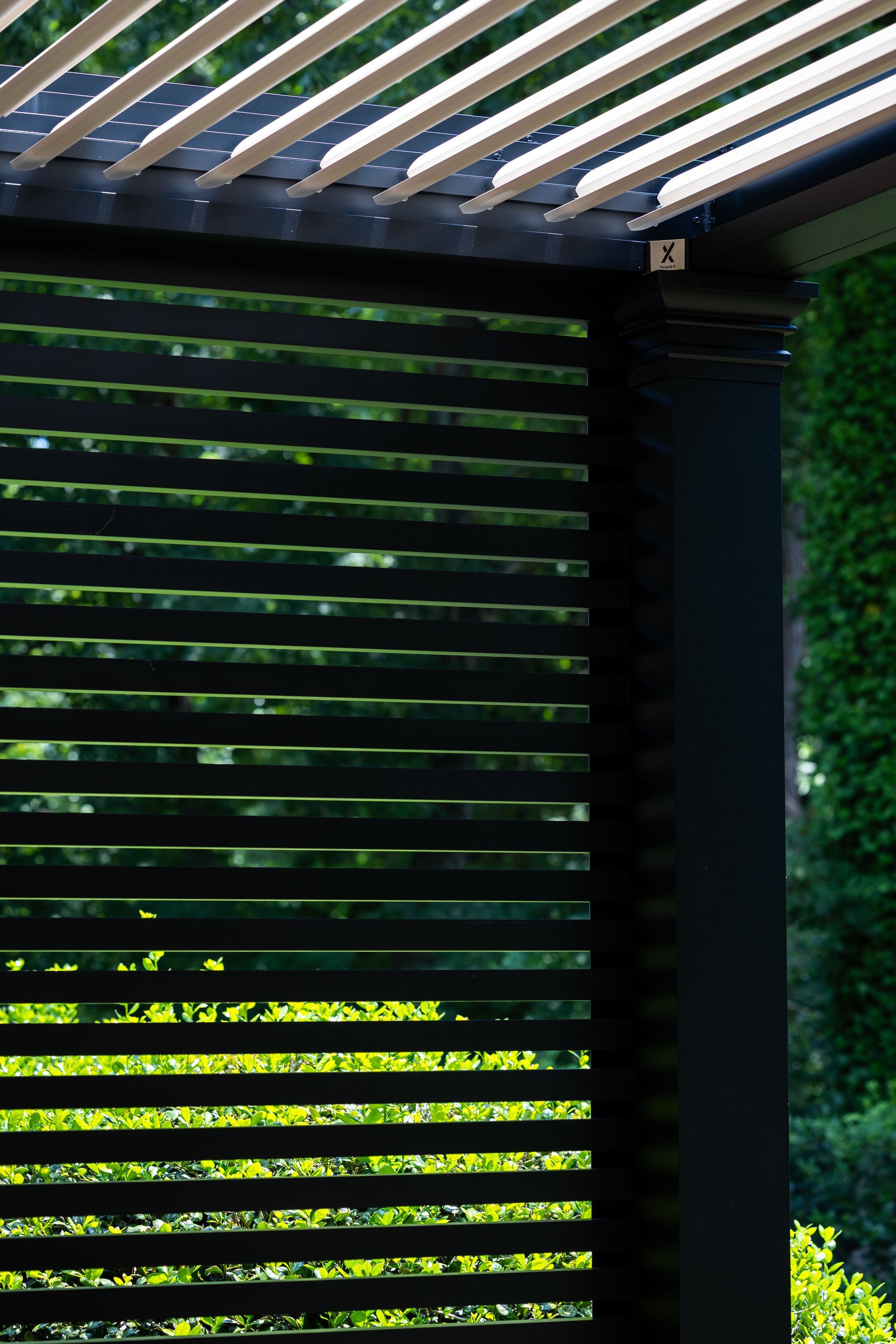A close up of a black shutter with a green background.