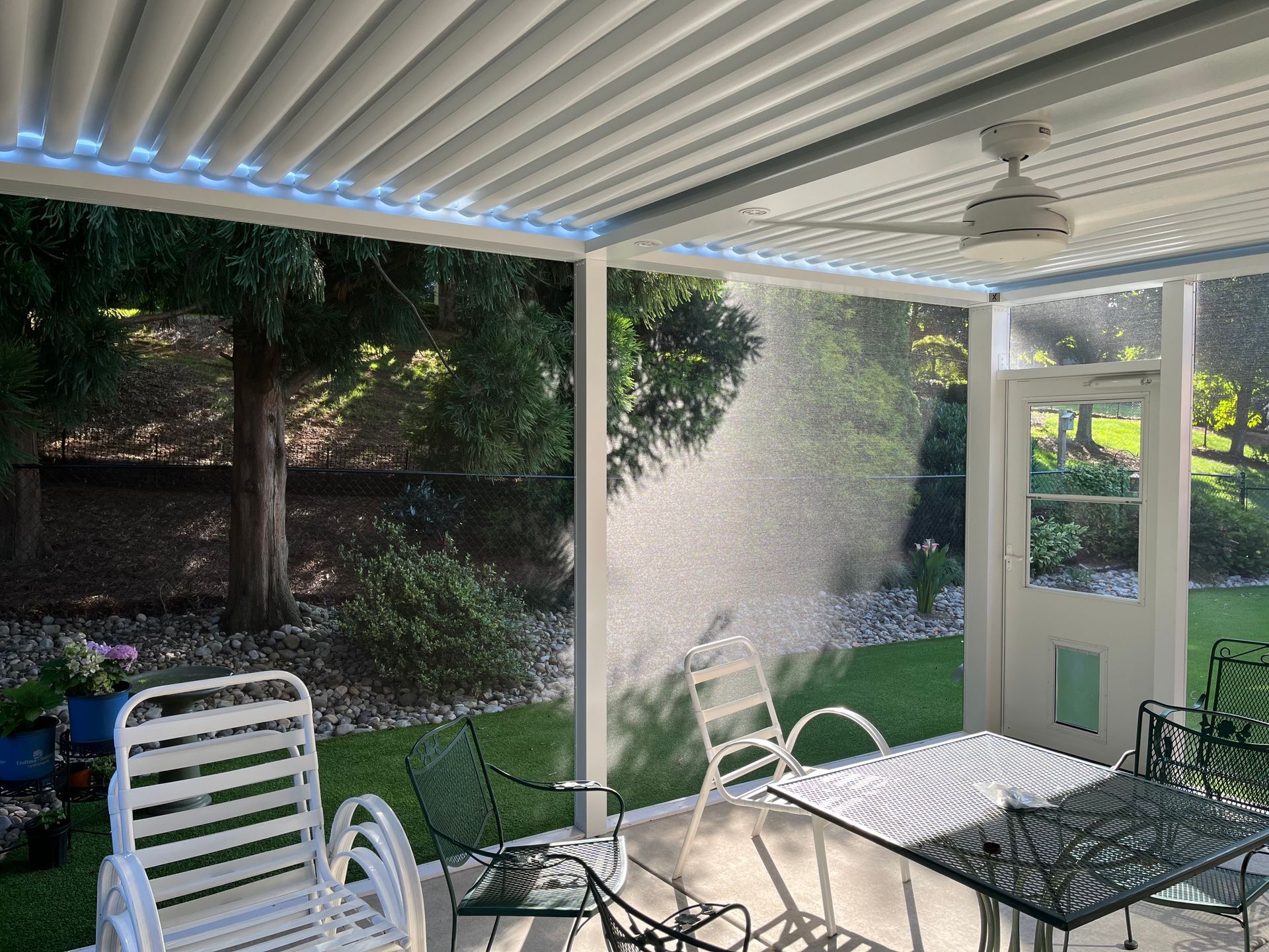 A patio with a table and chairs and a ceiling fan