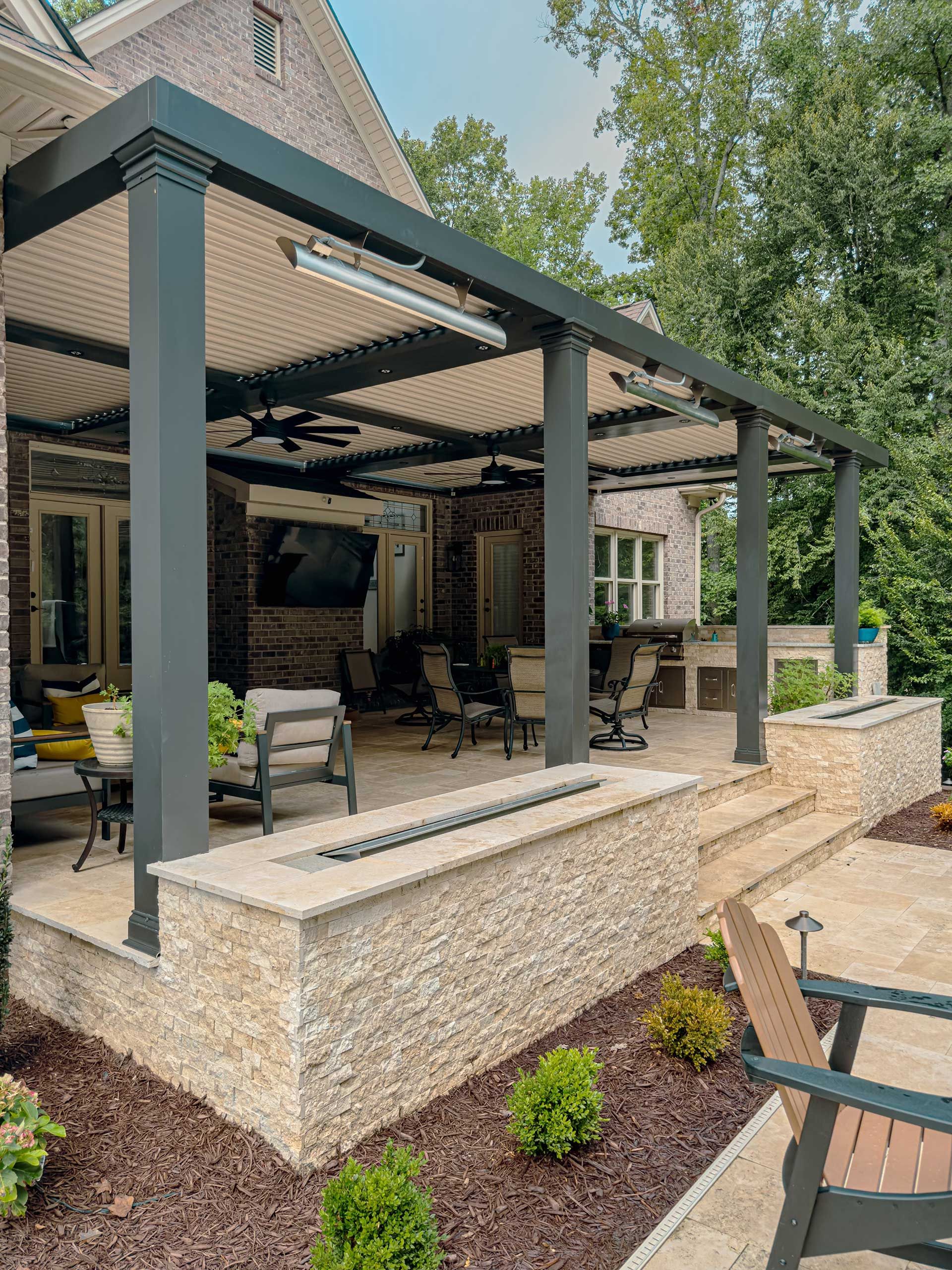A large covered patio with an outdoor living room, dining room, and kitchen