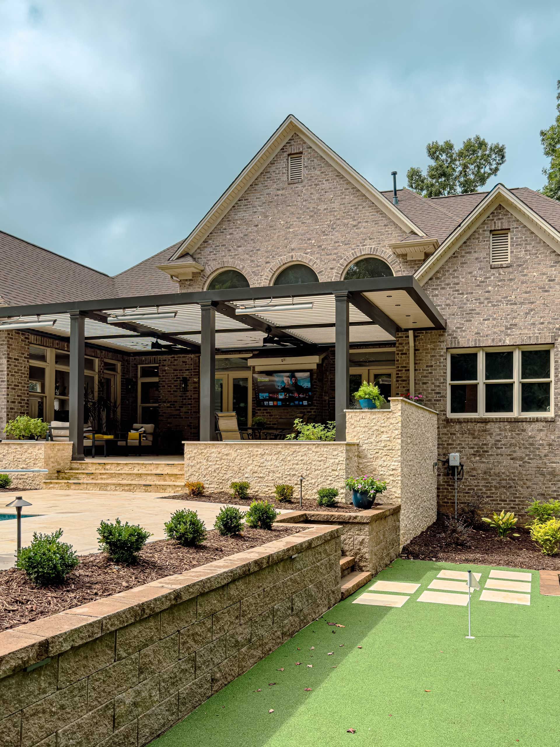 A large brick house with a pergola and a patio
