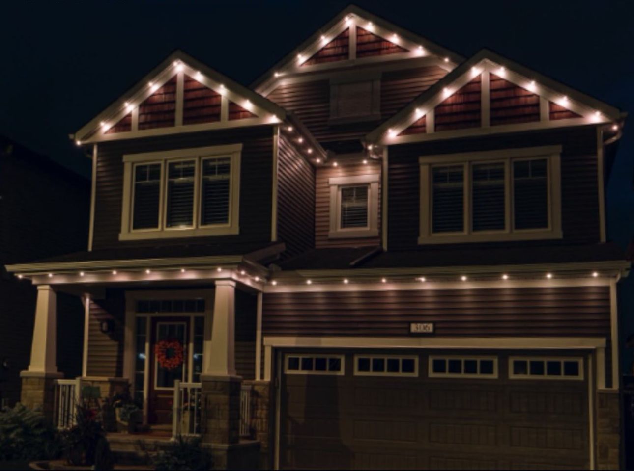 A house with Christmas lights on it is lit up at night