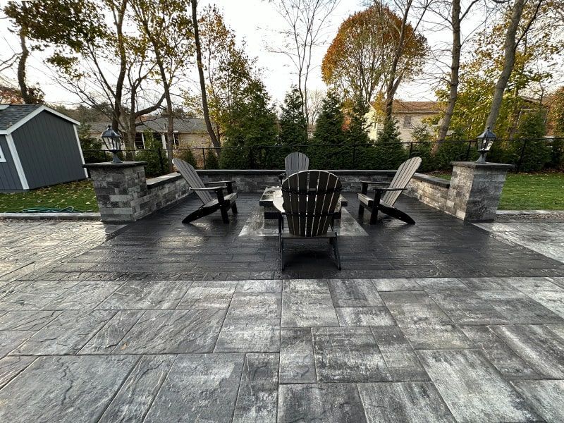 A patio with a table and chairs and a shed in the background.