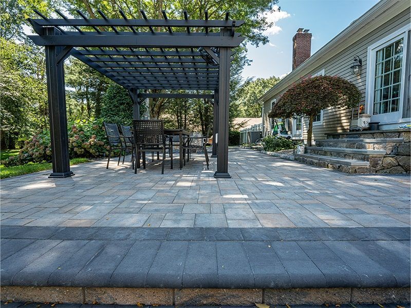 A patio with a table and chairs under a pergola.