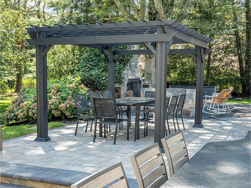 A patio with a table and chairs under a pergola.