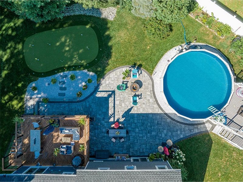 An aerial view of a backyard with a swimming pool and a putting green.