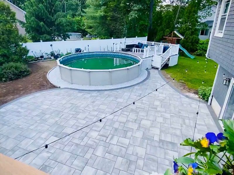 There is a swimming pool in the backyard of a house.