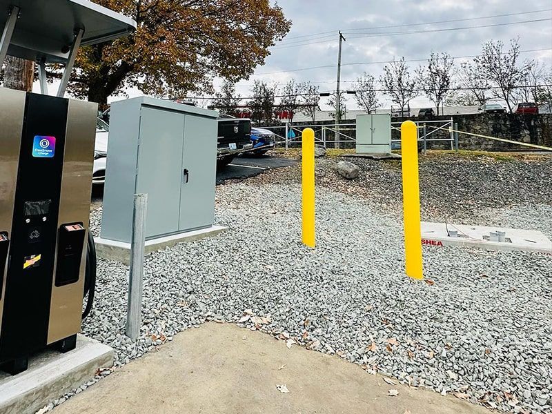 A parking lot with a gas pump and yellow poles