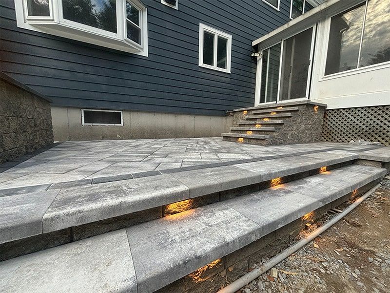 A patio with stairs leading up to a house.