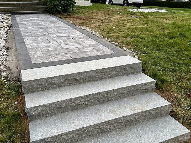 A stone walkway with stairs leading up to a house.