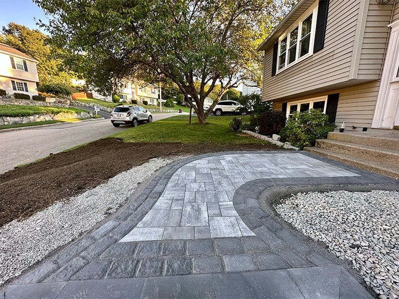 A brick walkway is being built in front of a house.