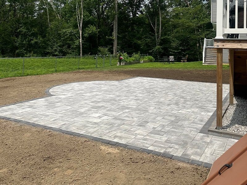 A patio is being built in the backyard of a house.