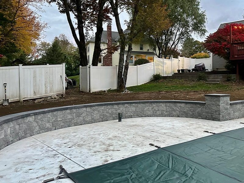A swimming pool is being built in the backyard of a house.