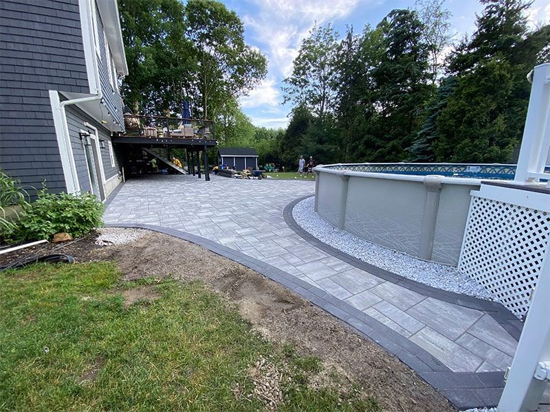A patio with a pool in the backyard of a house.