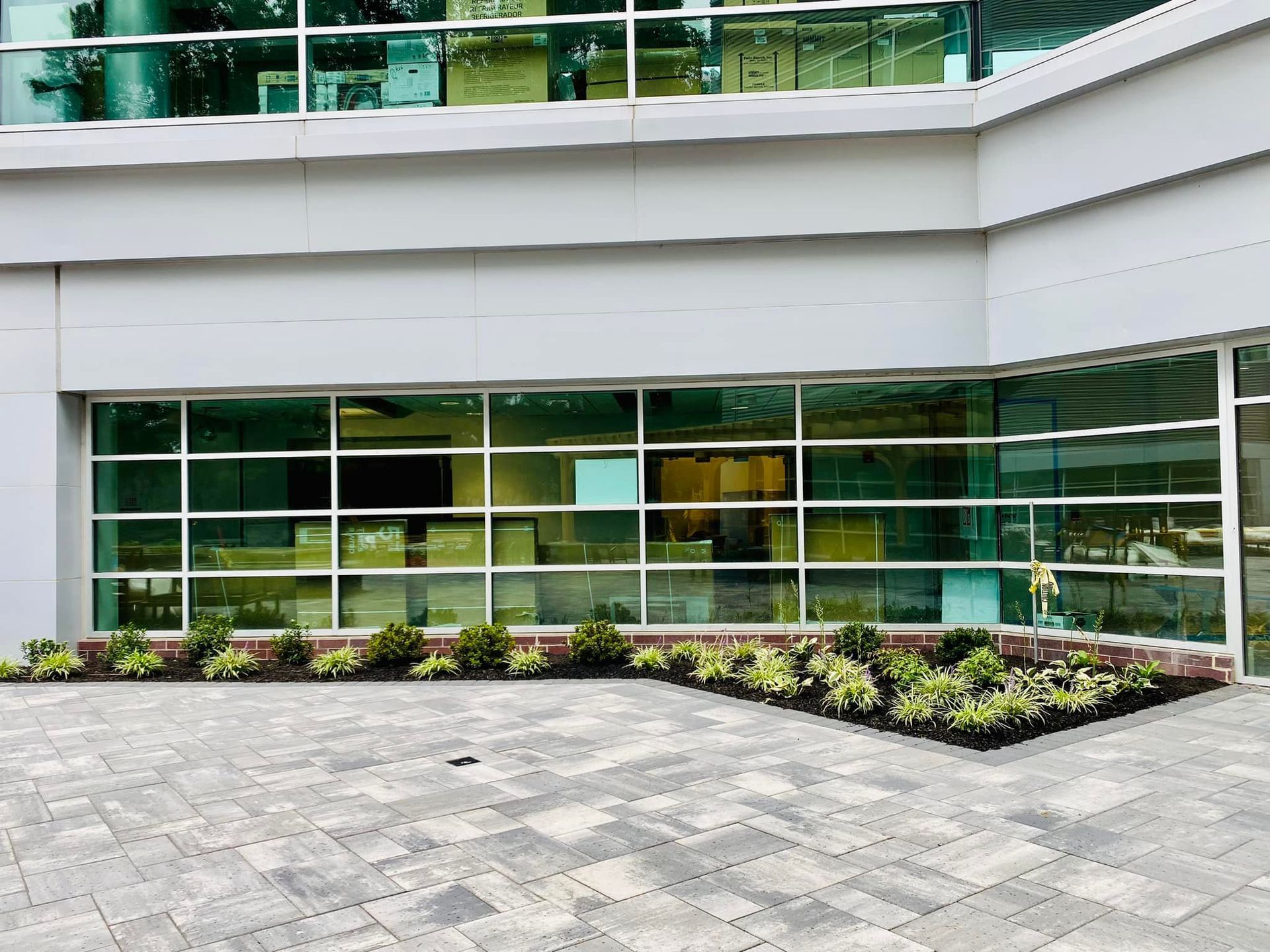 A building with a lot of windows and a brick driveway