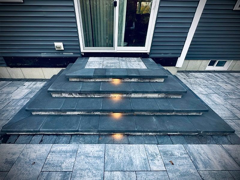 A set of stairs leading up to a house with lights on them.