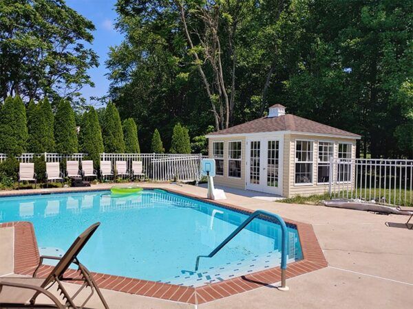 A large swimming pool with a gazebo in the background