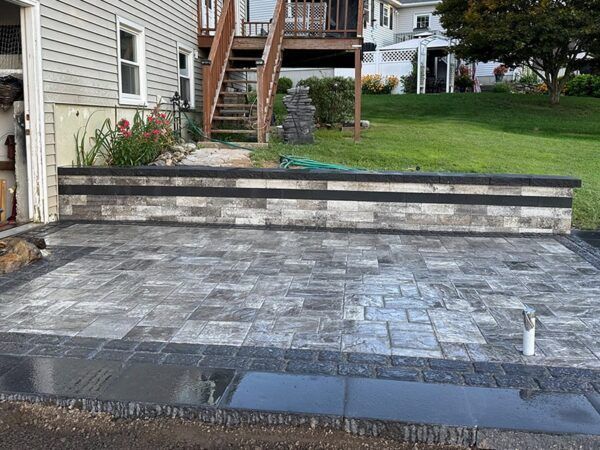 A brick driveway is being built in front of a house.