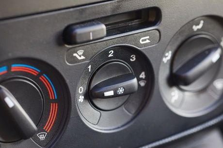 A close up of a car 's air conditioning control panel