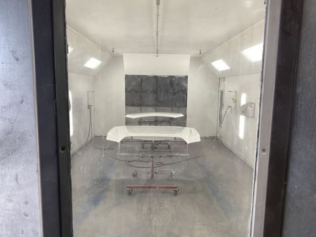 A car is being painted in a paint booth.