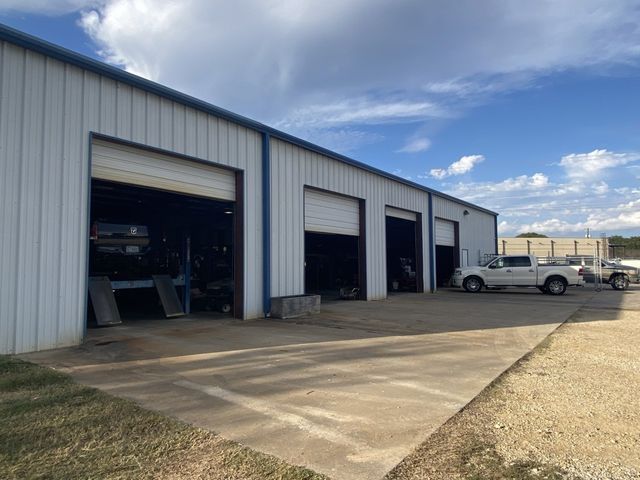 A white truck is parked in front of a garage.