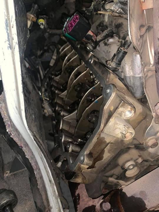 A close up of a car engine with a lot of wires coming out of it.