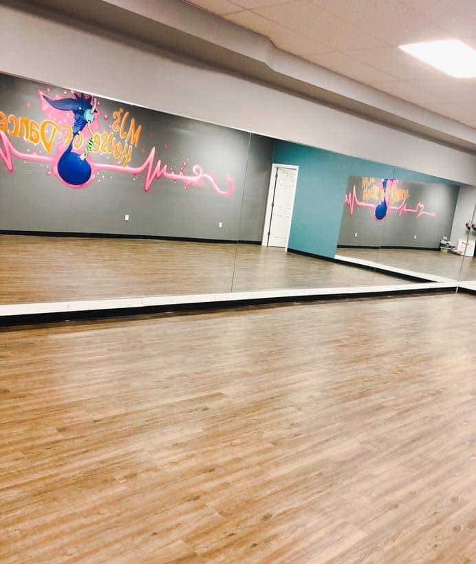 An empty dance studio with a large mirror on the wall