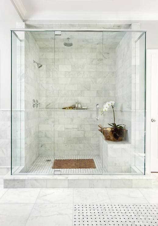 A bathroom with a walk in shower with a sliding glass door.
