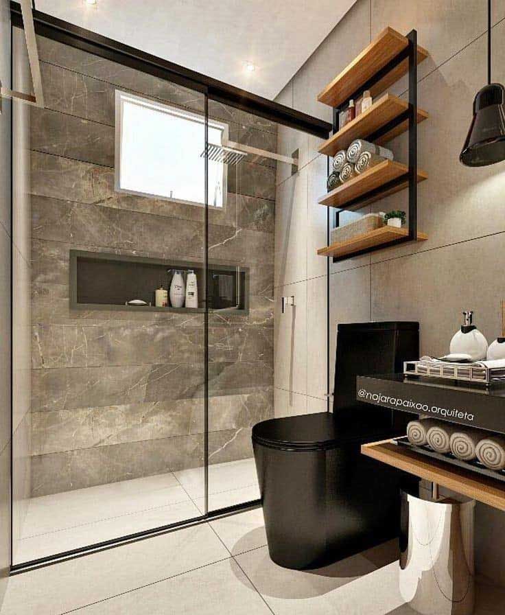 A bathroom with a toilet, sink, shower and window.