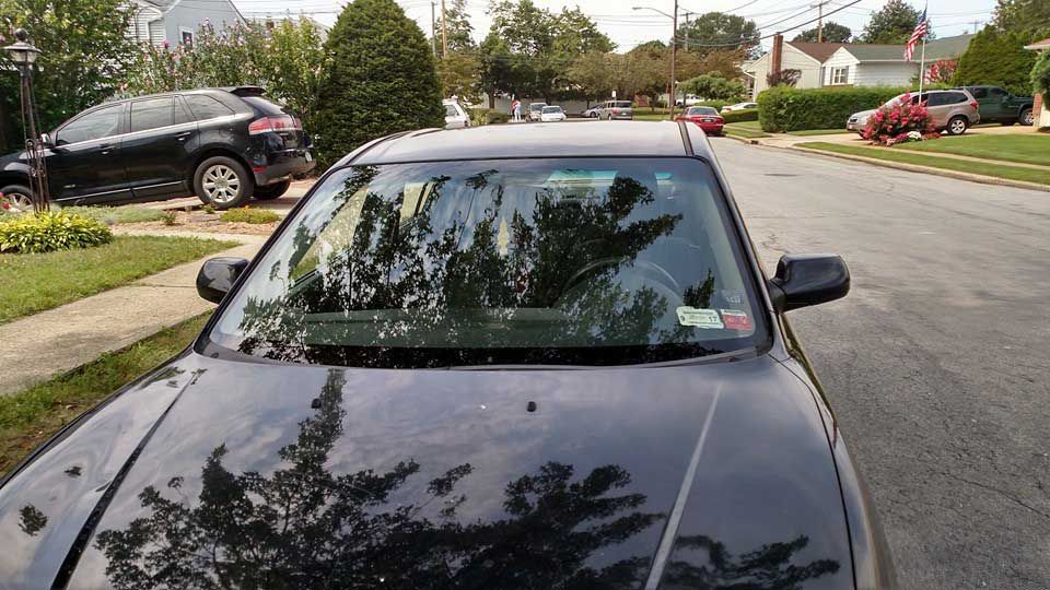 A black car is parked on the side of the road