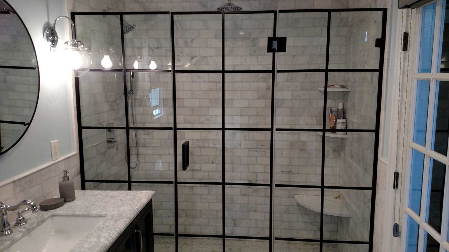A bathroom with a walk in shower and a sink.