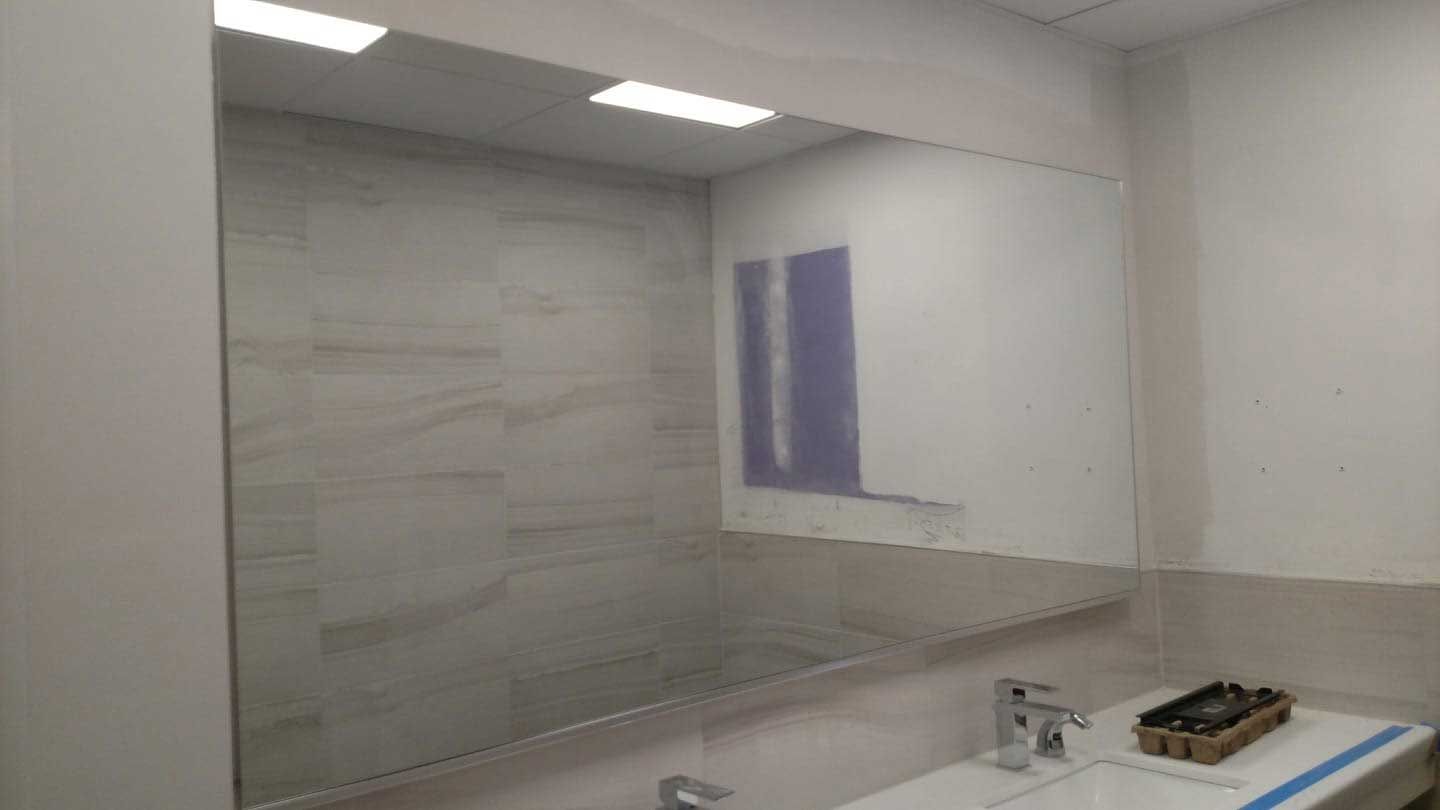 A bathroom with a large mirror and a sink.