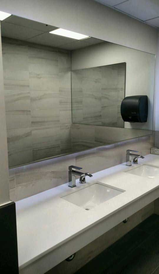 A bathroom with two sinks and a large mirror.