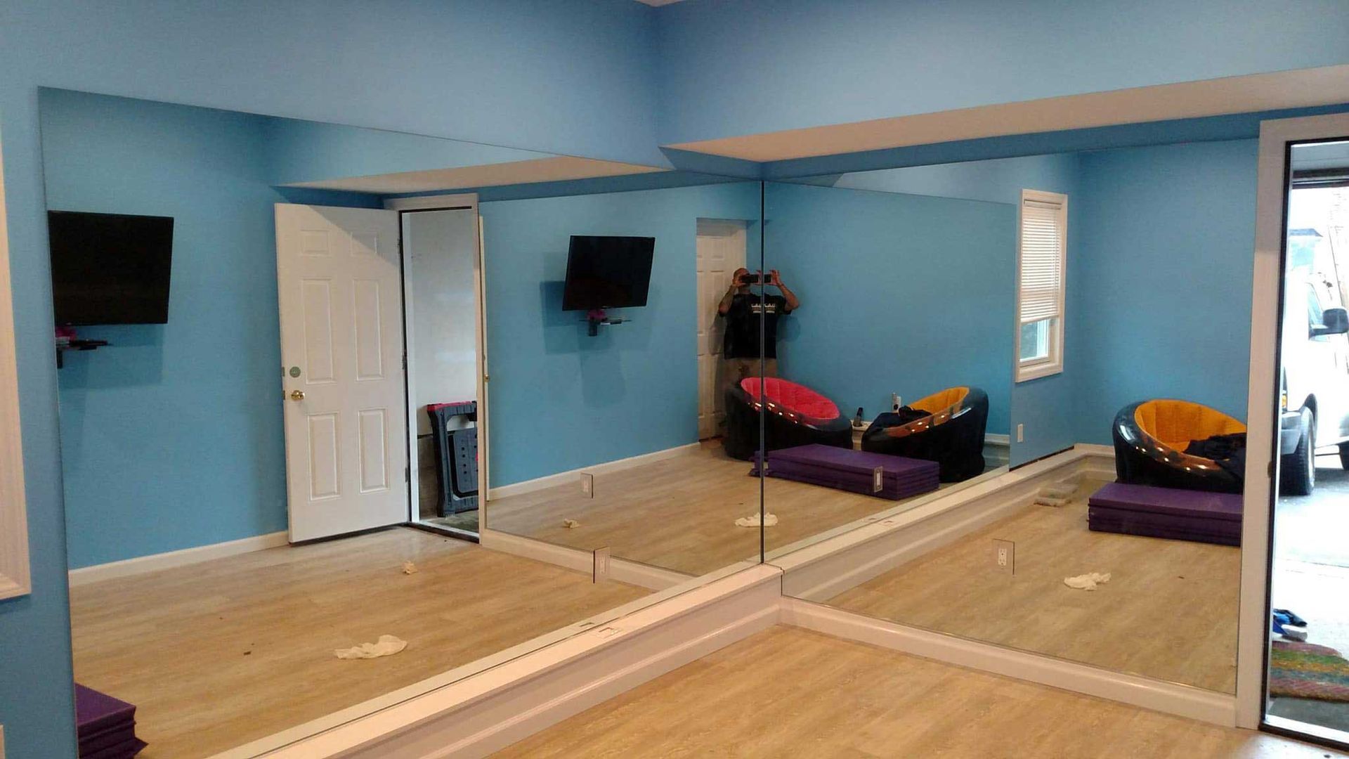 A room with a lot of mirrors on the wall and floor.