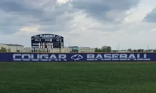 Baseball field with a scoreboard and a banner that reads 