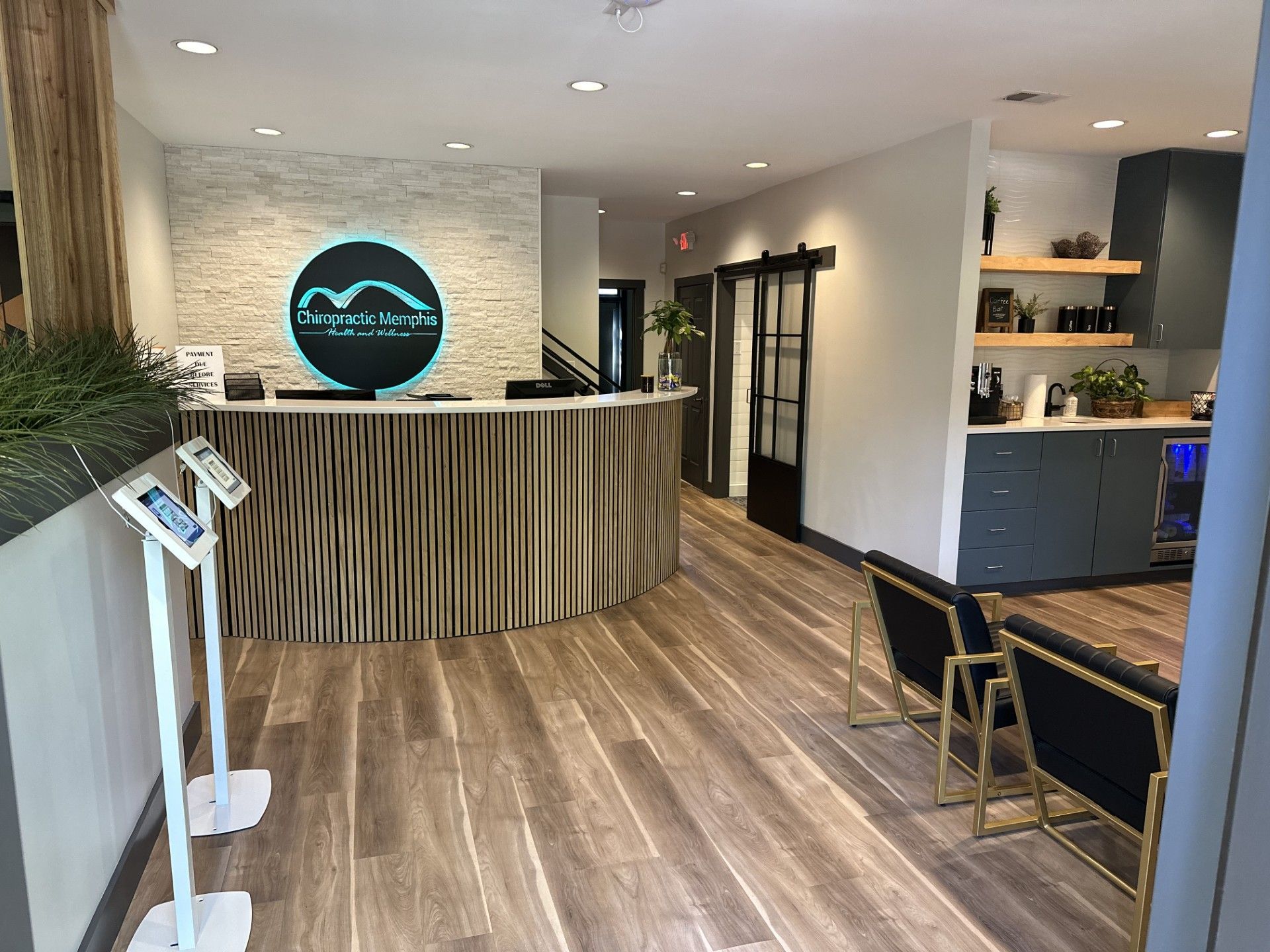 The inside of a dental office with a wooden floor and a reception desk.