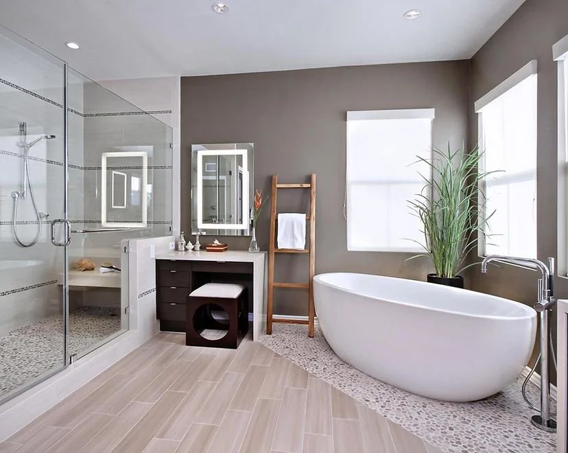 A bathroom with a tub , sink , mirrors and a walk in shower
