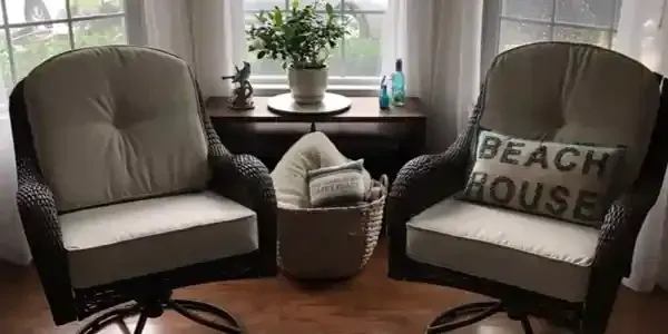 Two chairs in a living room with a pillow that says beach house.