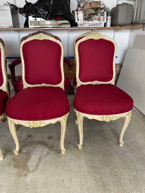 Three red and white chairs are sitting next to each other in a garage.