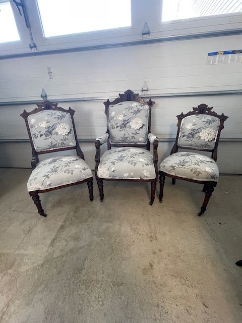 Three chairs are sitting in front of a garage door.