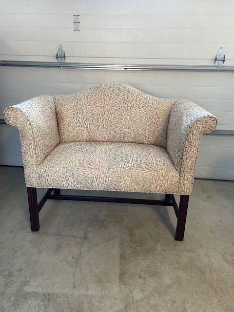 A white couch is sitting in a garage next to a garage door.