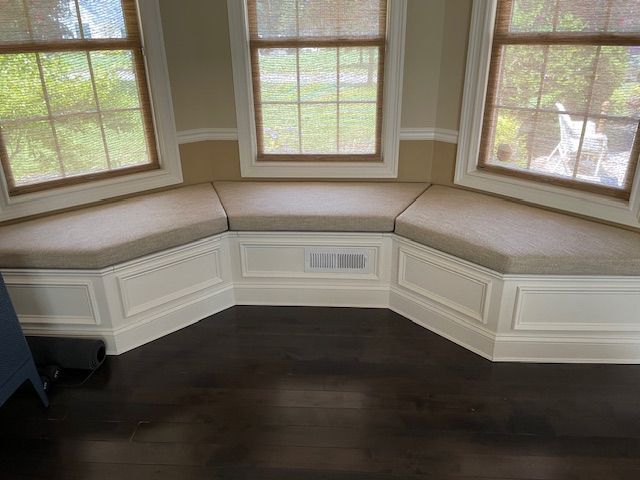 There is a window seat in the corner of the room.