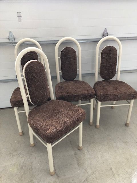 Four chairs are sitting next to each other in a garage.