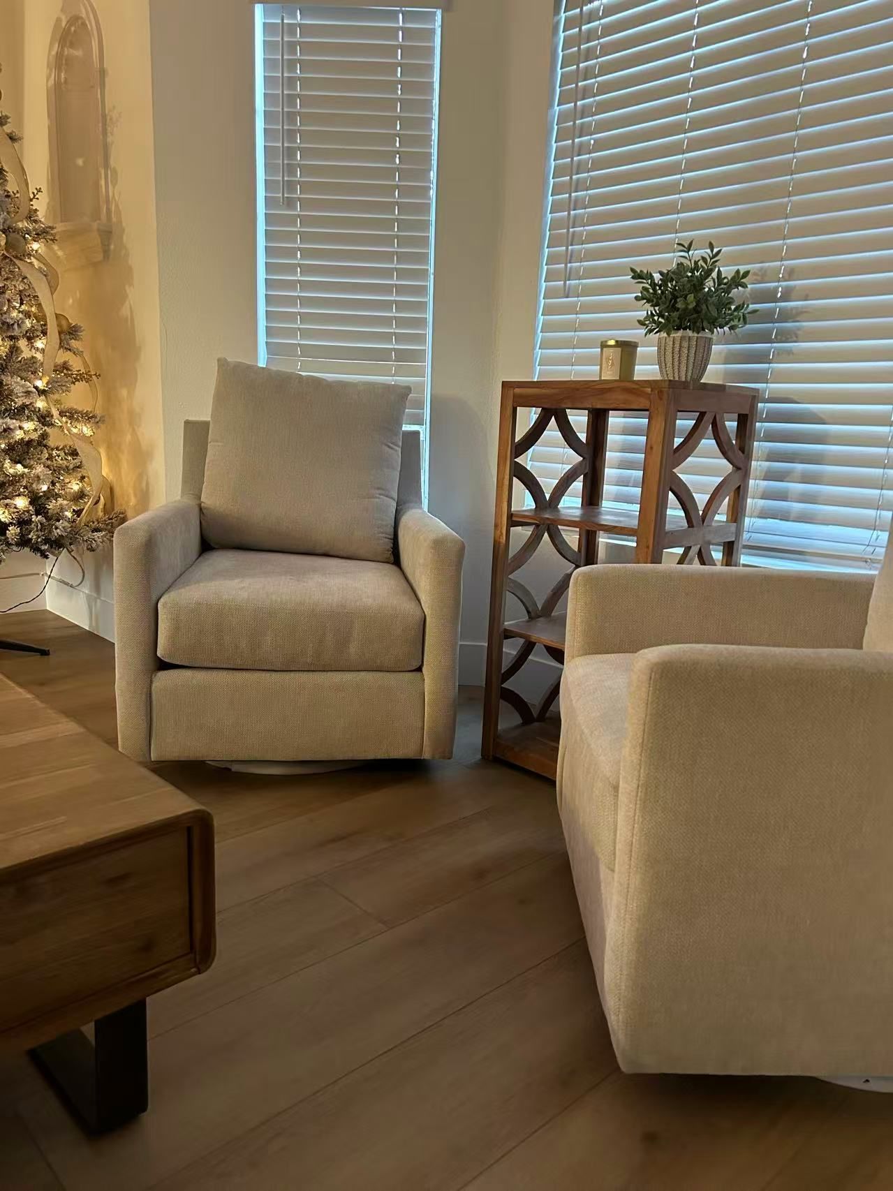 A living room with two chairs and a christmas tree.