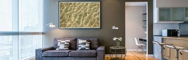 A living room with a couch and a painting on the wall.