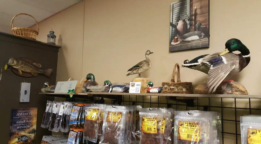 Shelf display with taxidermied ducks and products for sale.