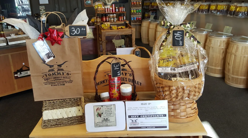 Gift baskets and products displayed on wooden tables inside a store.