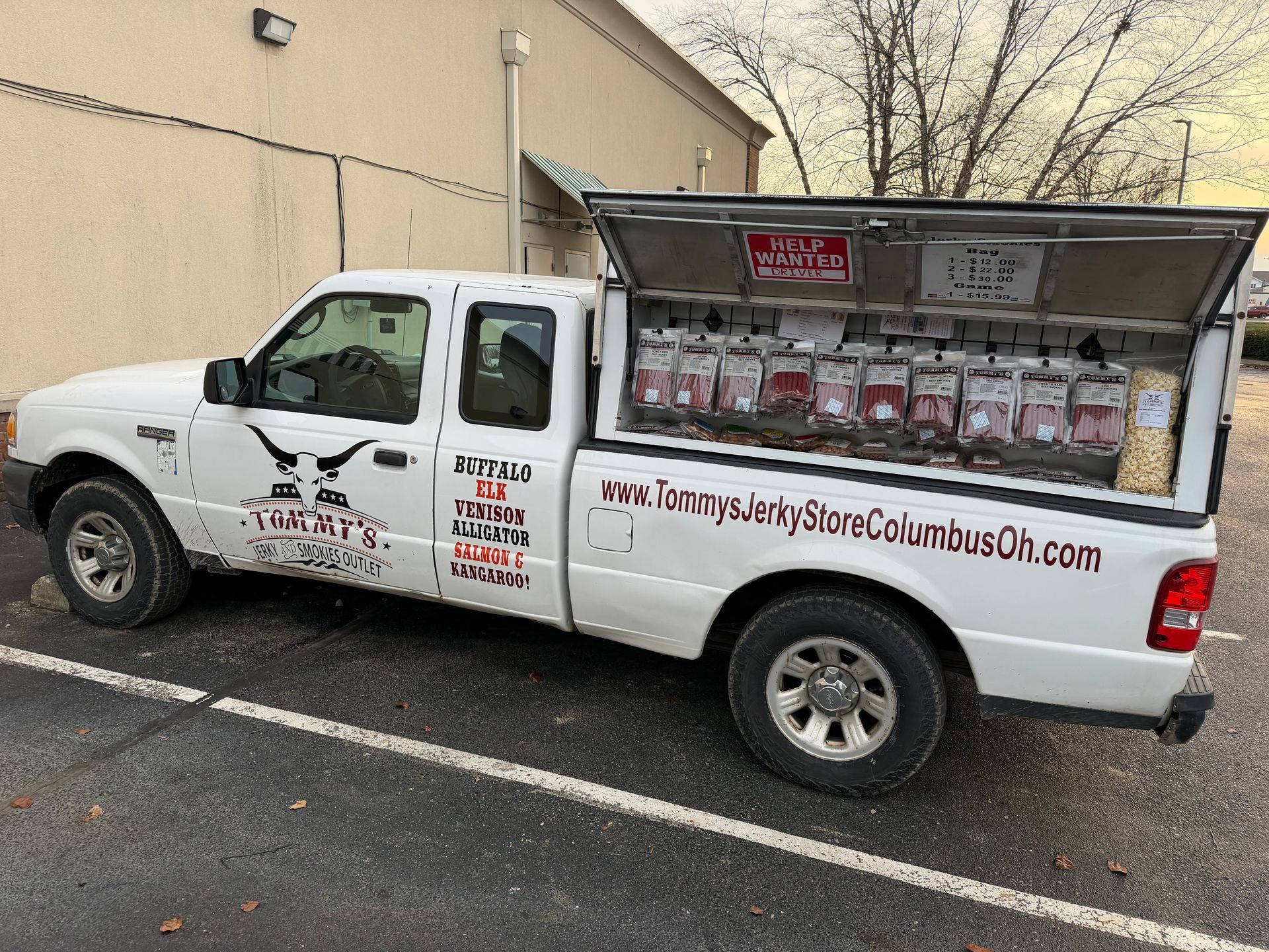 White truck selling jerky, side open displaying packaged jerky products. Columbus, OH.